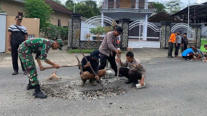 Polisi TNI dan warga perbaiki jalan rusak di Kampak Trenggalek