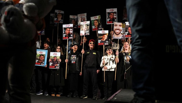 A man holds a placard as families and supporters of the Israeli hostages kidnapped during the deadly October 7 2023 attack by Hamas attend a demonstration in support of ceasefire deal between Israel and Hamas, the day before it goes into effect, in Jerusalem, January 18, 2025. REUTERS/Ammar Awad     TPX IMAGES OF THE DAY