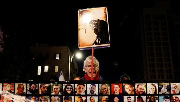 A man holds a placard as families and supporters of the Israeli hostages kidnapped during the deadly October 7 2023 attack by Hamas attend a demonstration in support of ceasefire deal between Israel and Hamas, the day before it goes into effect, in Jerusalem, January 18, 2025. REUTERS/Ammar Awad     TPX IMAGES OF THE DAY