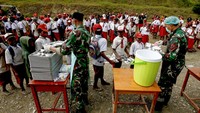 Anggota TNI melayani siswa yang mengantre untuk mendapatkan menu makan bergizi gratis perdana di SD Santo Michael Bilogae, Distrik Sugapa, Kabupaten Intan Jaya, Papua Tengah, Senin (20/1/2025).   