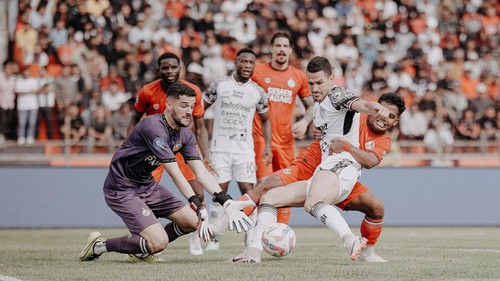 Boris Kopitovic (jersey putih) ditempel ketat di depan kotak pinalti Semen Padang. Boris mencetak 1 dari 5 gol kemenangan Bali United, Senin (20/1/2025). (Foto: Dok. Bali United)