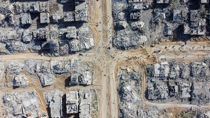 A drone view shows Palestinians walking past the rubble of houses and buidlings, following a ceasefire between Israel and Hamas, in Jabalia in the northern Gaza Strip, January 19, 2025. REUTERS/Mahmoud Al-Basos TPX IMAGES OF THE DAY