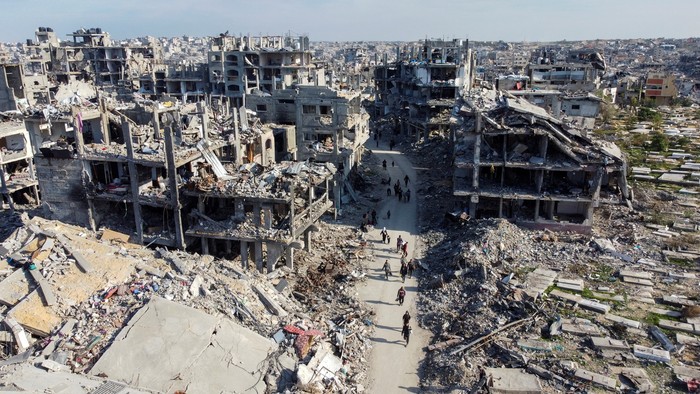 A drone view shows Palestinians walking past the rubble of houses and buidlings, following a ceasefire between Israel and Hamas, in Jabalia in the northern Gaza Strip, January 19, 2025. REUTERS/Mahmoud Al-Basos     TPX IMAGES OF THE DAY