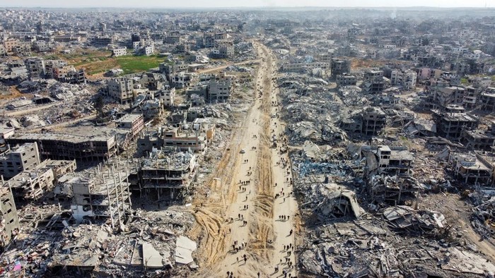 A drone view shows Palestinians walking past the rubble of houses and buidlings, following a ceasefire between Israel and Hamas, in Jabalia in the northern Gaza Strip, January 19, 2025. REUTERS/Mahmoud Al-Basos     TPX IMAGES OF THE DAY