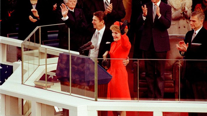 U.S. President Ronald Reagan and his wife, first lady Nancy Reagan, wave to the crowd on the west front of the Capitol building in Washington, D.C., after he was sworn in as the nations 40th president, Jan. 20, 1981.  Applauding behind the Reagans a