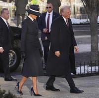 Berbasis di New York City, Adam Lippes mendesain setelan mantel double breasted. Di dalam luaran tersebut, terdapat atasan berkerah putih. Melania kemudian melengkapi gayanya dengan sepatu dan sarung tangan senada. (Foto: AP Photo/Matt Rourke)