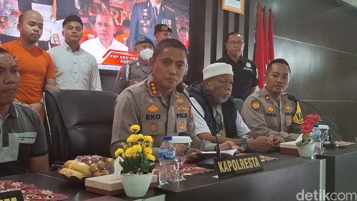Kapolresta Bogor Kota, Kombes Eko Prasetyo, menghadirkan pembunuh satpam Septian bernama Abraham Michael yang berbaju oranye di belakangnya. (M Sholihin/detikcom)