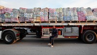 Seorang pria berdiri di dekat truk pengangkut bantuan, di perbatasan Rafah antara Mesir dan Jalur Gaza, di tengah gencatan senjata antara Israel dan Hamas, di Rafah, Mesir, Minggu (19/1/2025).  