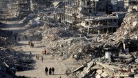 Warga Palestina berjalan melewati puing-puing rumah dan bangunan yang hancur selama perang, menyusul gencatan senjata antara Israel dan Hamas, di Rafah di Jalur Gaza selatan, Senin (20/1/2025).