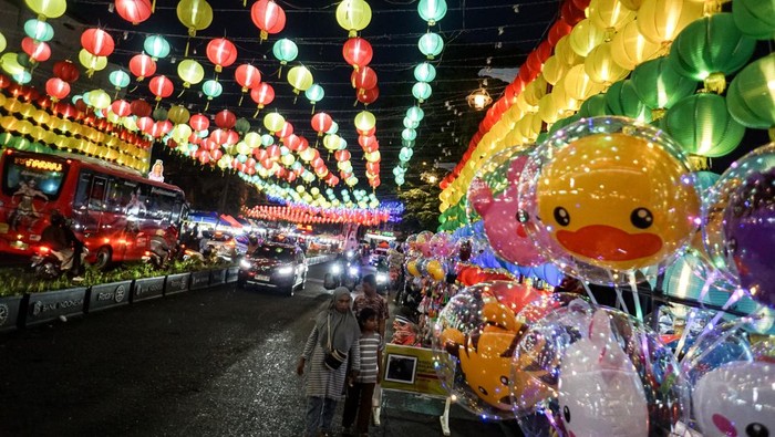 Warga melintas di depan dekorasi lampion bertema Imlek yang terpasang di sepanjang jalan Jenderal Sudirman Solo, Jawa Tengah, Senin (20/1/2025). Panitia Imlek Solo memasang lima ribu lampion di sepanjang jalan Jenderal Sudirman kawasan Pasar Gede untuk memeriahkan Tahun Baru Imlek sekaligus sebagai upaya meningkatkan daya tarik wisata yang berkunjung ke Kota Solo. ANTARA FOTO/Mohammad Ayudha /tom.