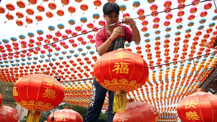 Pekerja memasang lampion hias di Maha Vihara Maitreya, Kabupaten Deli Serdang, Sumatera Utara, Senin (20/1/2025). Sebanyak 5.000 lampion dipasang di Vihara tersebut untuk menyambut perayaan Imlek pada 29 Januari 2025. ANTARA FOTO/Yudi Manar/YU