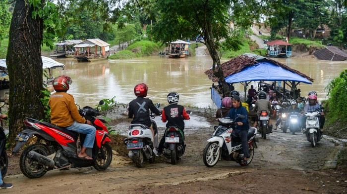 Tak Ada Jembatan, Masyarakat Seberangi Sungai Pakai Perahu Eretan Pengendara sepeda motor menaiki perahu eretan menyeberangi sungai Ciujung di Kragilan, Kabupaten Serang, Banten, Senin (20/1/2025). Warga setempat terpaksa menggunakan perahu eretan bertarif Rp2.000 itu sebagai moda penyeberangan untuk melintasi Sungai Ciujung guna mempersingkat jarak tempuh karena tidak adanya akses jembatan penyeberangan di wilayah tersebut. ANTARA FOTO/Muhammad Bagus Khoirunas/rwa.
