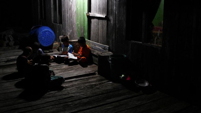 Anak suku Bajo belajar kelompok dibantu penerangan lampu lilin di Desa Lakarama, Kecamatan Towea, Muna, Sulawesi Tenggara, Minggu (19/1/2025). Desa Lakarama dihuni 1.287 jiwa tersebut belum mendapatkan aliran listrik pemerintah namun warga mengandalkan aliran listrik dari mesin genset milik usaha pribadi yang beroperasi dari pukul 17.30 Wita sampai 23.30 Wita setiap hari dengan iuran Rp90 ribu per bulan. ANTARA FOTO/Jojon/foc.