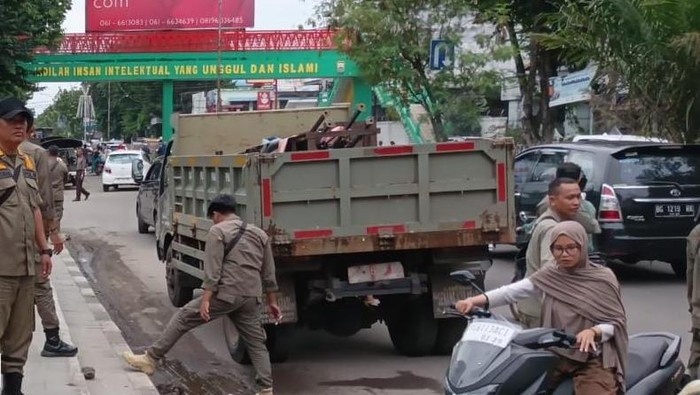 Anggota Satpol-PP Palembang melakukan penertiban di Jalan Ahmad Yani Plaju