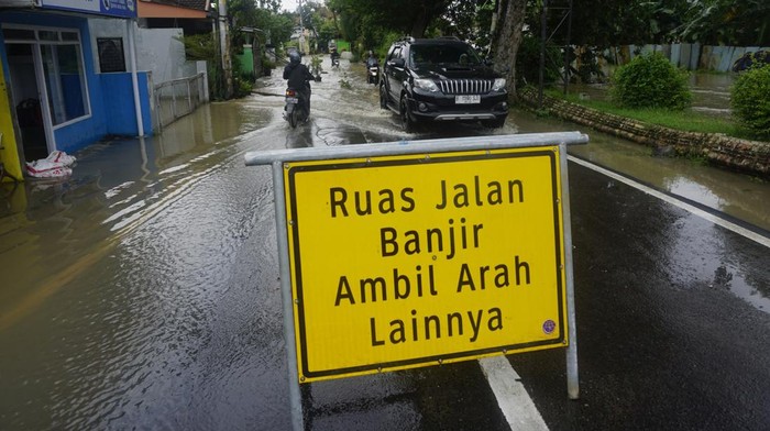 Warga menuntun kendaraannya melintasi banjir di Kebonharjo, Patebon, Kendal, Jawa Tengah, Selasa (21/1/2025). Ribuan rumah di 7 desa yang tersebar di 4 kecamatan di kabupaten Kendal terendam banjir akibat jebolnya tanggul Kali Bodri. ANTARA FOTO/Anis Efizudin/rwa.