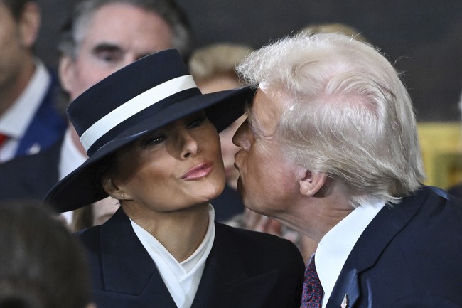 Topi tak pernah lepas dari penampilan Melania, bahkan ketika seremoni pelantikan berlangsung di dalam Gedung Capitol. Trump sempat terlihat kesulitan mencium sang istri gara-gara topi tersebut. Gayanya lantas menjadi sorotan, tak sedikit pula membandingkan penampilan Melania dengan Hamburglar, kartun penjahat versi restoran cepat saji McDonald. (Foto: Saul Loeb/Pool photo via AP)