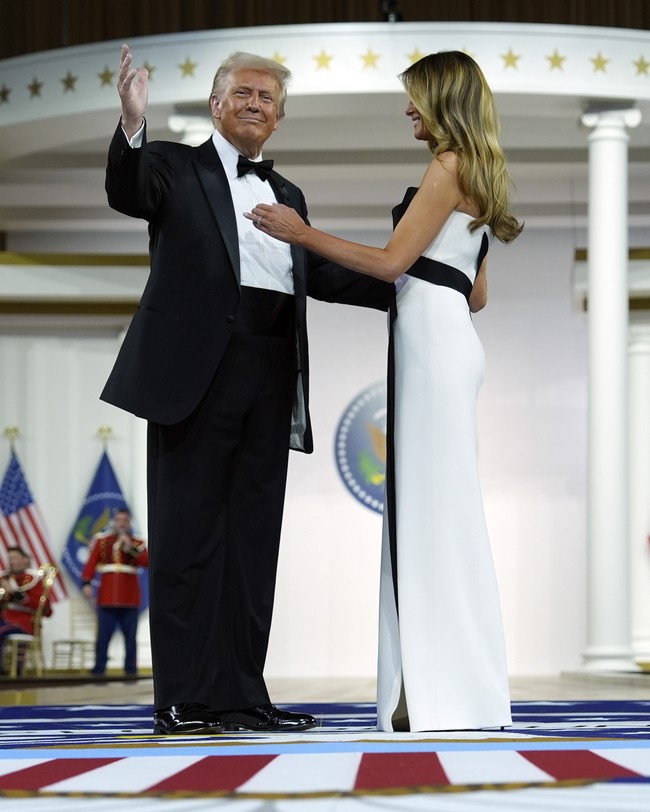 Rambut Melania dibiarkan tergerai bebas. Berbeda dari penampilan sebelumnya saat pelantikan, rambut tertutup topi. (Foto: AP Photo/Evan Vucci)