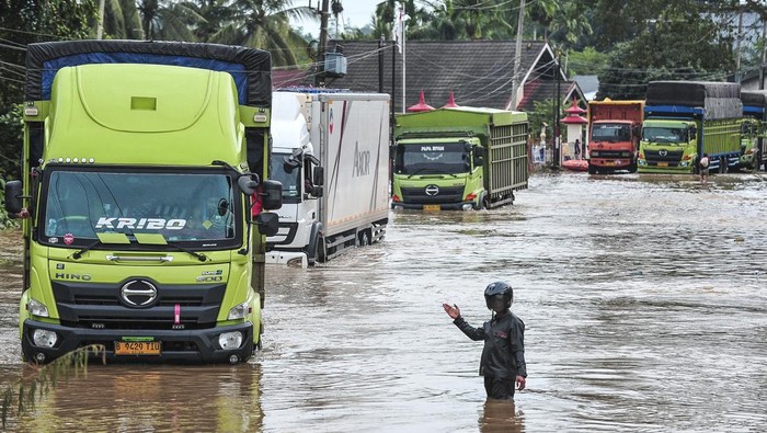 Foto udara petugas mobil derek mengevakuasi sebuah truk yang terjebak banjir di Jalan Lintas Sumatera, Merlung, Jambi, Senin (20/1/2025). Arus lalu lintas di jalan nasional yang sempat lumpuh total selama lebih dari 24 jam atau sejak Minggu (19/1/2025) sore akibat banjir setinggi 150 sentimeter dan terjebaknya dua buah mobil di tengah-tengah banjir itu sudah berhasil dilalui dengan sistem buka tutup. ANTARA FOTO/Wahdi Septiawan.