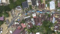 Foto udara petugas mobil derek mengevakuasi sebuah truk yang terjebak banjir di Jalan Lintas Sumatera yang dipenuhi antrean kendaraan di Merlung, Jambi, Senin (20/1/2025). 