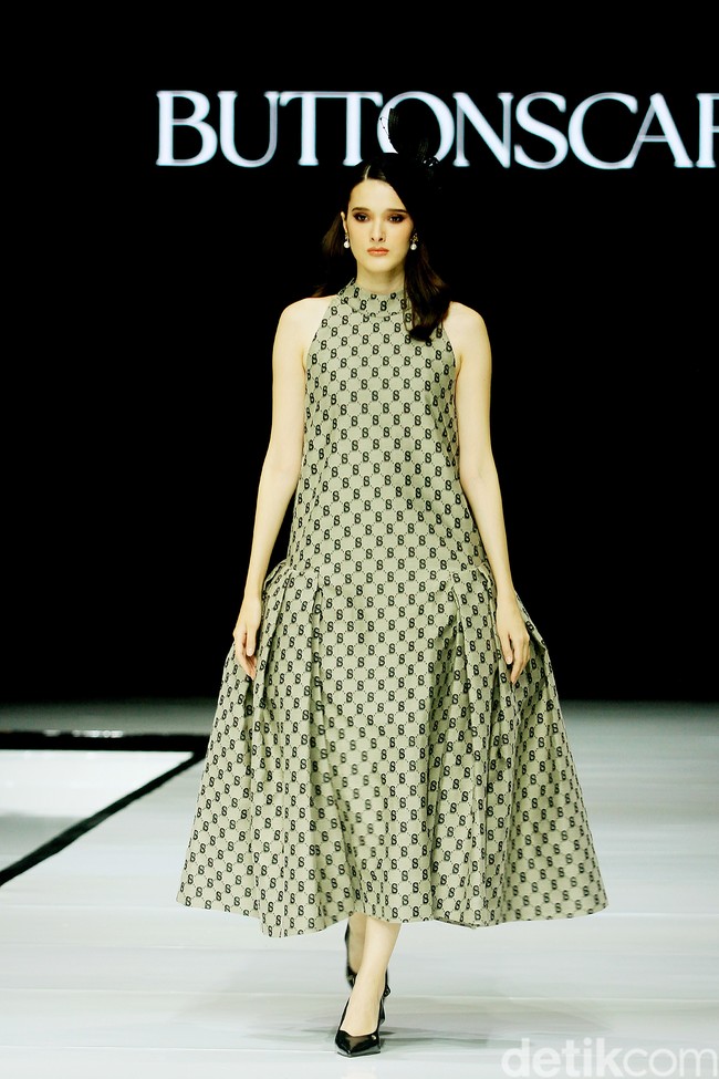 Monogram ‘B’ telah menjadi ciri khas koleksi busana Buttonscarves. Memasuki tahun ke-9, jenama yang didirikan Linda Anggrea ini mengemasnya dengan tampilan baru. Monogram dari logo Buttonscarves tersebut menghiasi 24 set busana yang muncul di peragaan bertajuk ‘Shades of Noire’ yang digelar di acara Garis Poetih Raya Festival 2025, Pondok Indah Mall, Jakarta Selatan. Jumat [17/1/2025]. Foto: Mohammad Abduh/detikcom.