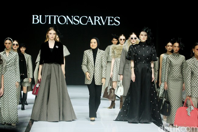 Monogram ‘B’ telah menjadi ciri khas koleksi busana Buttonscarves. Memasuki tahun ke-9, jenama yang didirikan Linda Anggrea ini mengemasnya dengan tampilan baru. Monogram dari logo Buttonscarves tersebut menghiasi 24 set busana yang muncul di peragaan bertajuk ‘Shades of Noire’ yang digelar di acara Garis Poetih Raya Festival 2025, Pondok Indah Mall, Jakarta Selatan. Jumat [17/1/2025]. Foto: Mohammad Abduh/detikcom.