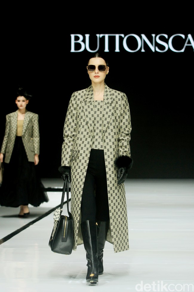 Monogram ‘B’ telah menjadi ciri khas koleksi busana Buttonscarves. Memasuki tahun ke-9, jenama yang didirikan Linda Anggrea ini mengemasnya dengan tampilan baru. Monogram dari logo Buttonscarves tersebut menghiasi 24 set busana yang muncul di peragaan bertajuk ‘Shades of Noire’ yang digelar di acara Garis Poetih Raya Festival 2025, Pondok Indah Mall, Jakarta Selatan. Jumat [17/1/2025]. Foto: Mohammad Abduh/detikcom.