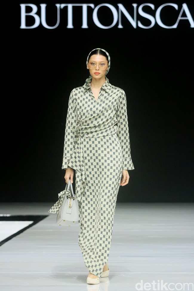 Monogram ‘B’ telah menjadi ciri khas koleksi busana Buttonscarves. Memasuki tahun ke-9, jenama yang didirikan Linda Anggrea ini mengemasnya dengan tampilan baru. Monogram dari logo Buttonscarves tersebut menghiasi 24 set busana yang muncul di peragaan bertajuk ‘Shades of Noire’ yang digelar di acara Garis Poetih Raya Festival 2025, Pondok Indah Mall, Jakarta Selatan. Jumat [17/1/2025]. Foto: Mohammad Abduh/detikcom.