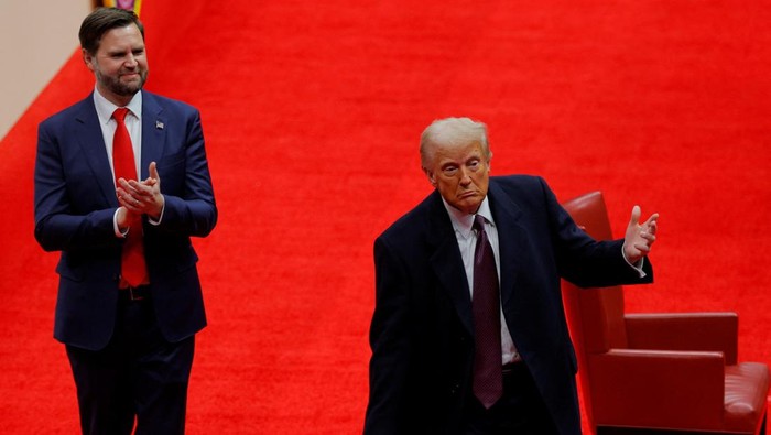 U.S. President Donald Trump throws a pen after he signed executive orders next to U.S. Vice President JD Vance on the inauguration day of Trumps second Presidential term, inside Capital One Arena, in Washington, U.S. January 20, 2025. REUTERS/Brian Snyder