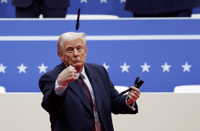 U.S. President Donald Trump throws a pen after he signed executive orders next to U.S. Vice President JD Vance on the inauguration day of Trumps second Presidential term, inside Capital One Arena, in Washington, U.S. January 20, 2025. REUTERS/Brian Snyder