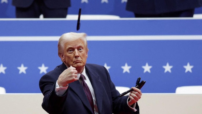U.S. President Donald Trump throws a pen after he signed executive orders next to U.S. Vice President JD Vance on the inauguration day of Trumps second Presidential term, inside Capital One Arena, in Washington, U.S. January 20, 2025. REUTERS/Brian Snyder