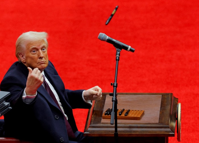 U.S. President Donald Trump throws a pen after he signed executive orders next to U.S. Vice President JD Vance on the inauguration day of Trumps second Presidential term, inside Capital One Arena, in Washington, U.S. January 20, 2025. REUTERS/Brian Snyder