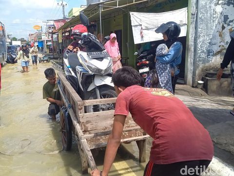 Jasa ojek gerobak Bangkalan membantu para pemotor yang terjebak genangan banjir