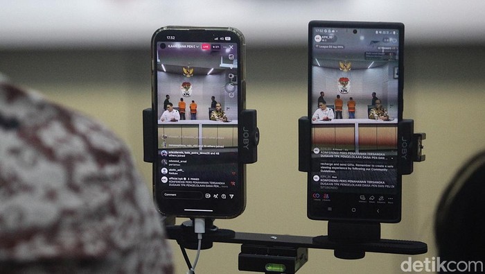 Bupati Situbondo, Jawa Timur Karna Suswandi (mengenakan masker) bersama Kepala Bidang Bina Marga PUPR Kabupaten Situbondo, Eko Prionggo digelandang petugas saat hendak ditahan di Gedung Merah Putih KPK, Jakarta, Selasa (21/1/2025). Keduanya ditahan karena diduga terlibat dalam korupsi pengelolaan dana Pemulihan Ekonomi Nasional (PEN) di Pemkab Situbondo periode 2021-2024.