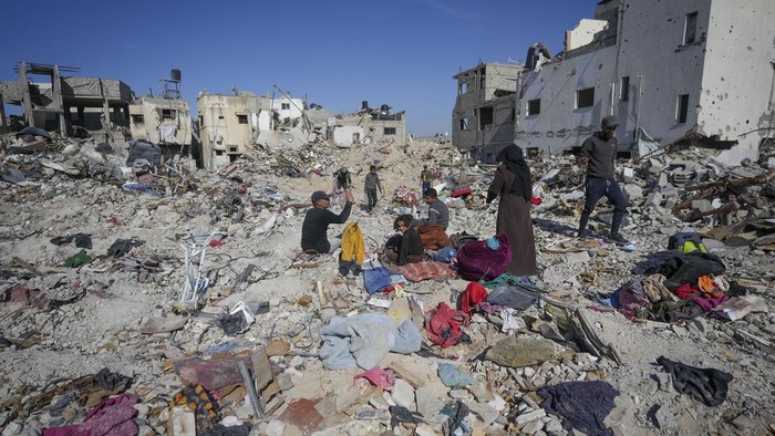 Mahmoud al-Azazi sits in a bedroom inside a destroyed home a day after the ceasefire deal between Israel and Hamas came into effect, in Rafah, southern Gaza Strip, Monday, Jan. 20, 2025,(AP Photo/Abdel Kareem Hana)