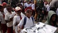 Para siswa mengantre untuk mendapatkan menu makan bergizi gratis di SD Bilogae, Distrik Sugapa, Kabupaten Intan Jaya, Papua Tengah.