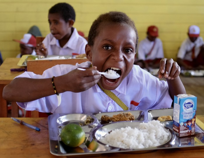 Senangnya Siswa SD di Papua Tengah Dapat Makan Gratis Perdana Seorang murid menyantap makanannya pada program makan bergizi gratis di SD Bilogae, Distrik Sugapa, Kabupaten Intan Jaya, Papua Tengah, Senin (20/1/2025). Sebanyak 337 penerima manfaat termasuk ibu hamil, menikmati sajian yang terdiri dari nasi putih, ayam goreng, nugget, kacang panjang, toge, tempe, buah jeruk, dan susu UHT pada pelaksanaan Program Makan Bergizi Gratis (MBG) perdana yang digelar Satgas Yonif 509 Kostrad di daerah tersebut.