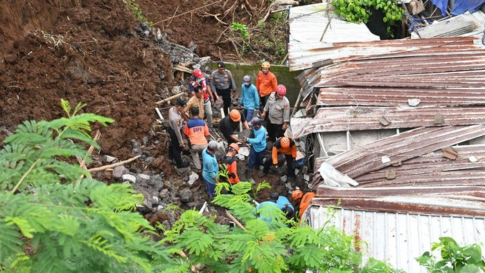 Warga melihat informasi kejadian tanah longsor di kawasan Ubung Kaja, Denpasar, Bali, Senin (20/1/2025). Peristiwa tanah longsor tersebut menimpa bangunan rumah kos yang mengakibatkan 5 orang meninggal dunia dan 3 korban luka. ANTARA FOTO/Fikri Yusuf/YU