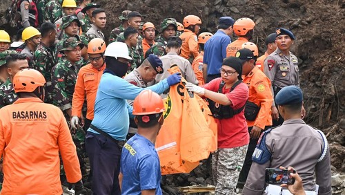 Warga melihat informasi kejadian tanah longsor di kawasan Ubung Kaja, Denpasar, Bali, Senin (20/1/2025). Peristiwa tanah longsor tersebut menimpa bangunan rumah kos yang mengakibatkan 5 orang meninggal dunia dan 3 korban luka. ANTARA FOTO/Fikri Yusuf/YU
