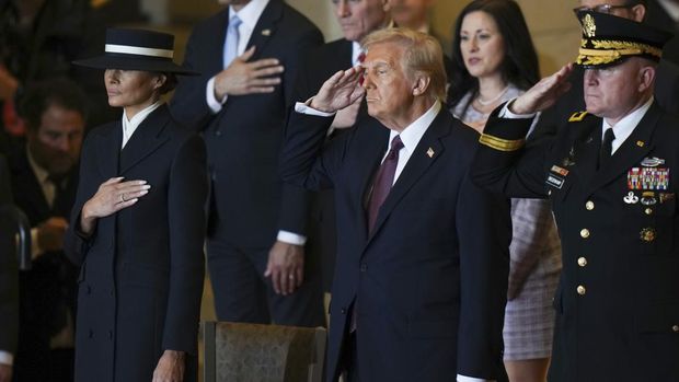 President Donald Trump, center, salutes at Emancipation Hall after the 60th Presidential Inauguration in the U.S. Capitol in Washington, Monday, Jan. 20, 2025. (Angelina Katsanis/Pool Photo Photo via AP)