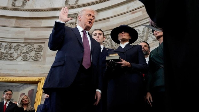 Donald Trump is sworn in as the 47th president of the United States by Chief Justice John Roberts as Melania Trump holds the Bible during the 60th Presidential Inauguration in the Rotunda of the U.S. Capitol in Washington, Monday, Jan. 20, 2025.     Morry Gash/Pool via REUTERS