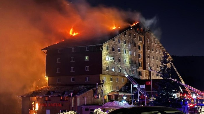 Firefighters work to extinguish a fire in a hotel at a ski resort of Kartalkaya in Bolu province, in northwest Turkey, Tuesday, Jan. 21, 2025. (IHA via AP)