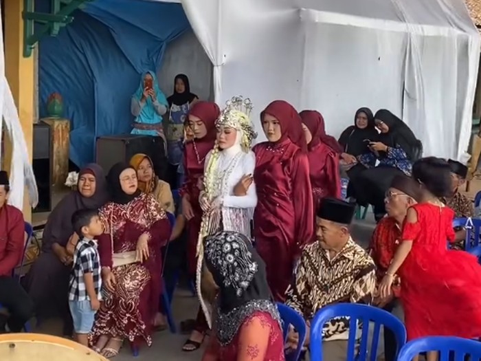 Ilustrasi pengantin berfoto diterpa angin kencang