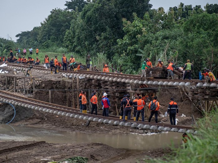Pekerja memperbaiki jalur kereta api (KA) km 32+5/7 akibat amblas tergerus banjir luapan air Sungai Tuntang di Gubug, Kabupaten Grobogan, Jawa Tengah, Rabu (22/1/2025). PT Kereta Api Indonesia (Persero) Daop 4 Semarang terus melakukan perbaikan dengan pengerahan puluhan pekerja dan alat berat guna mempercepat perbaikan dan sejumlah perjalanan KA yang terganggu masih dilakukan rekayasa pola operasi berupa pengalihan rute perjalanan KA. ANTARA FOTO/Aji Styawan/agr