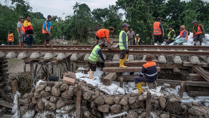 Begini Perbaikan Jalur Kereta Api Amblas di Grobogan Pekerja memperbaiki jalur kereta api (KA) km 32+5/7 akibat amblas tergerus banjir luapan air Sungai Tuntang di Gubug, Kabupaten Grobogan, Jawa Tengah, Rabu (22/1/2025). PT Kereta Api Indonesia (Persero) Daop 4 Semarang terus melakukan perbaikan dengan pengerahan puluhan pekerja dan alat berat guna mempercepat perbaikan dan sejumlah perjalanan KA yang terganggu masih dilakukan rekayasa pola operasi berupa pengalihan rute perjalanan KA. ANTARA FOTO/Aji Styawan/agr