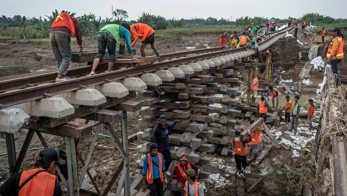 Pekerja memperbaiki jalur kereta api (KA) km 32+5/7 akibat amblas tergerus banjir luapan air Sungai Tuntang di Gubug, Kabupaten Grobogan, Jawa Tengah, Rabu (22/1/2025). PT Kereta Api Indonesia (Persero) Daop 4 Semarang terus melakukan perbaikan dengan pengerahan puluhan pekerja dan alat berat guna mempercepat perbaikan dan sejumlah perjalanan KA yang terganggu masih dilakukan rekayasa pola operasi berupa pengalihan rute perjalanan KA. ANTARA FOTO/Aji Styawan/agr