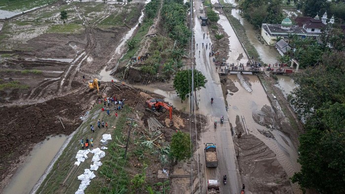 Foto udara petugas mengoperasikan alat berat saat perbaikan tanggul Sungai Tuntang yang jebol di Kecamatan Kebonagung, Kabupaten Demak, Jawa Tengah, Rabu (22/1/2025). BBWS Pemali-Juana mengerahkan empat ekskavator dan puluhan pekerja dalam upaya memperbaiki tanggul yang jebol akibat banjir luapan Sungai Tuntang pada Selasa (21/1) dan memutus jalur utama Semarang-Purwodadi. ANTARA FOTO/Aji Styawan/agr