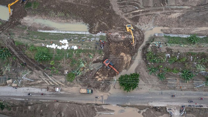 Foto Udara Perbaikan Tanggul Sungai Jebol di Demak Foto udara petugas mengoperasikan alat berat saat perbaikan tanggul Sungai Tuntang yang jebol di Kecamatan Kebonagung, Kabupaten Demak, Jawa Tengah, Rabu (22/1/2025). BBWS Pemali-Juana mengerahkan empat ekskavator dan puluhan pekerja dalam upaya memperbaiki tanggul yang jebol akibat banjir luapan Sungai Tuntang pada Selasa (21/1) dan memutus jalur utama Semarang-Purwodadi. ANTARA FOTO/Aji Styawan/agr