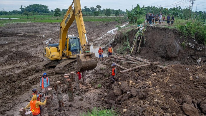 Foto Udara Perbaikan Tanggul Sungai Jebol di Demak Foto udara petugas mengoperasikan alat berat saat perbaikan tanggul Sungai Tuntang yang jebol di Kecamatan Kebonagung, Kabupaten Demak, Jawa Tengah, Rabu (22/1/2025). BBWS Pemali-Juana mengerahkan empat ekskavator dan puluhan pekerja dalam upaya memperbaiki tanggul yang jebol akibat banjir luapan Sungai Tuntang pada Selasa (21/1) dan memutus jalur utama Semarang-Purwodadi. ANTARA FOTO/Aji Styawan/agr