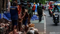 Para pekerja terlihat bahu-membahu membuat lubang secara manual.  