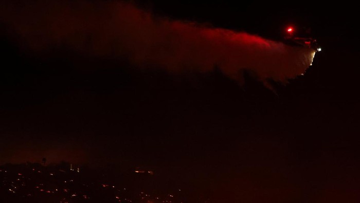 Hutan di San Diego California Ikut Membara A firefighter works at the site of a wildfire, named the Lilac Fire, in the Bonsall area of San Diego County, California, U.S., January 21, 2025. REUTERS/Mike Blake